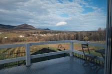 An outdoor balcony with seating and a breathtaking view of the landscape.
