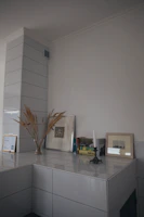 Minimalist living room corner featuring a ceramic sculpture on a wooden shelf.