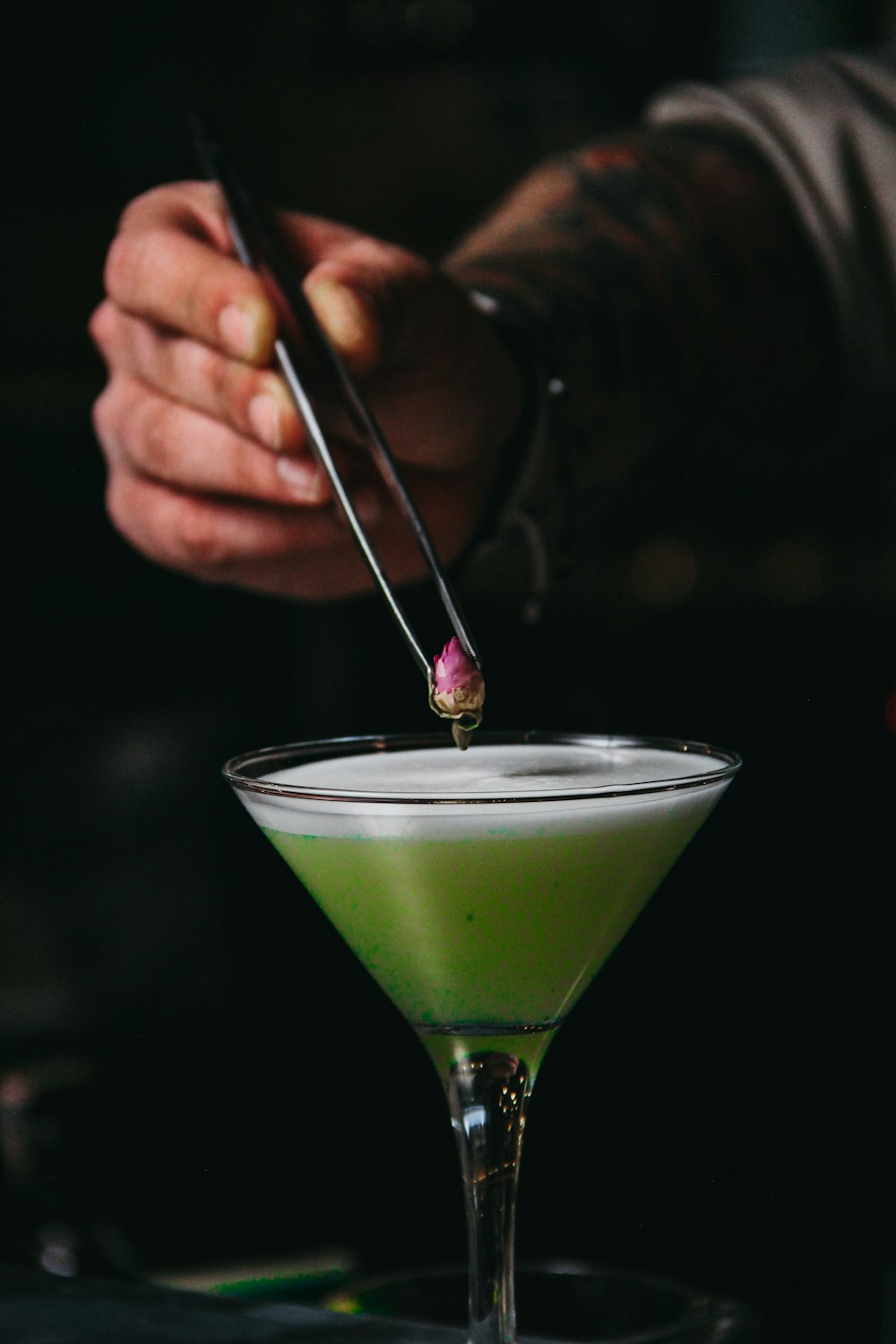 a person is preparing a drink in a martini glass