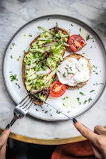 a white plate topped with an open face sandwich
