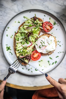 a white plate topped with an open face sandwich