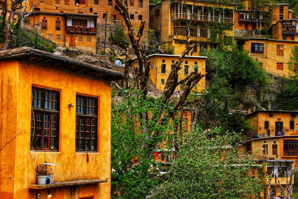 a yellow building with many windows on a hillside