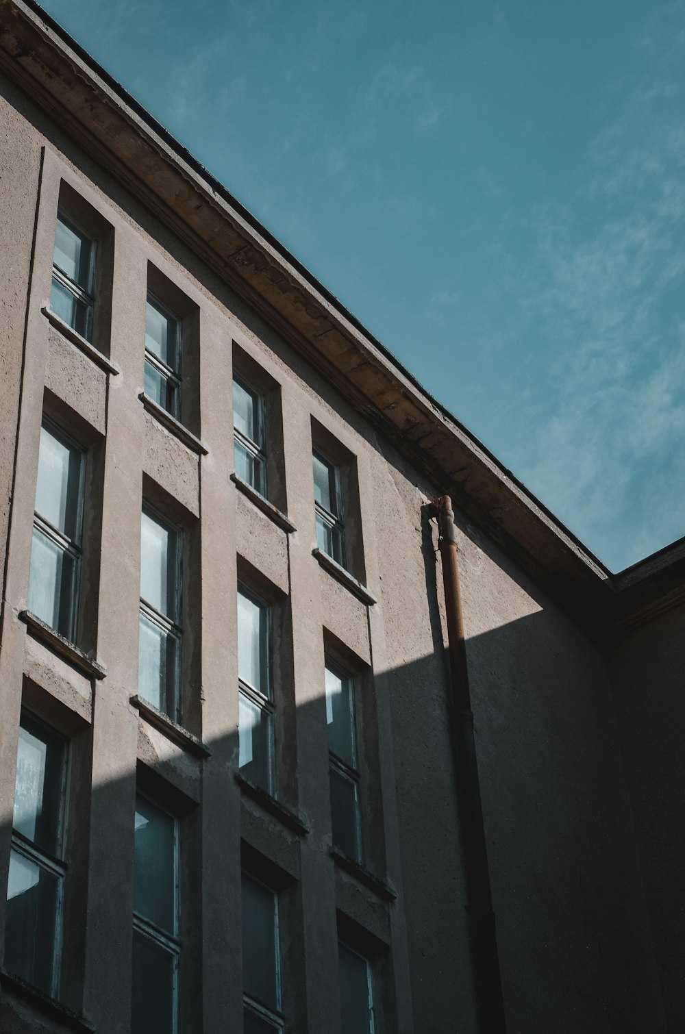 a tall building with lots of windows next to a blue sky