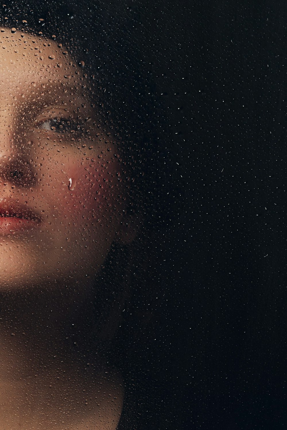 a close up of a woman looking out a window