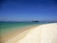 A serene beach view with clear blue waters and soft white sand.