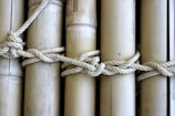 Artisan lashing bamboo canes together with traditional rope techniques.