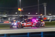 A fast-paced racing game moment capturing cars speeding on a neon-lit track.