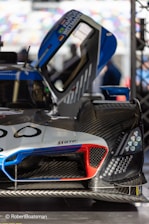 Close-up of a CFD simulation on a sleek racing car model with blue electric highlights.