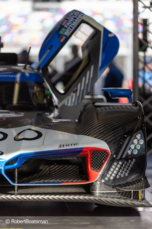 Close-up of a CFD simulation on a sleek racing car model with blue electric highlights.