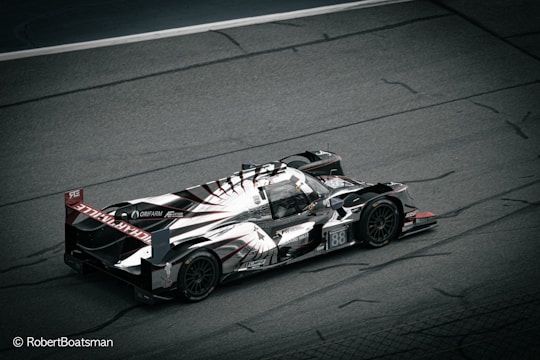 A sleek, high-performance racing car is captured on a motor racing track. The car features an aerodynamic design with prominent branding and markings, including the number 88. The image is taken from a high angle, showcasing the car's intricate details and emphasizing its speed and agility.