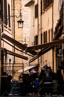 A cozy, sunlit café terrace tucked away on a quiet cobblestone street, with locals enjoying coffee and conversation.