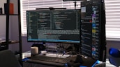 A minimalist desk setup featuring dual monitors showing front-end development and automation tools.