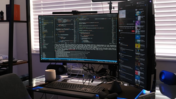 A developer coding on a dual-monitor setup with e-commerce analytics on screen.