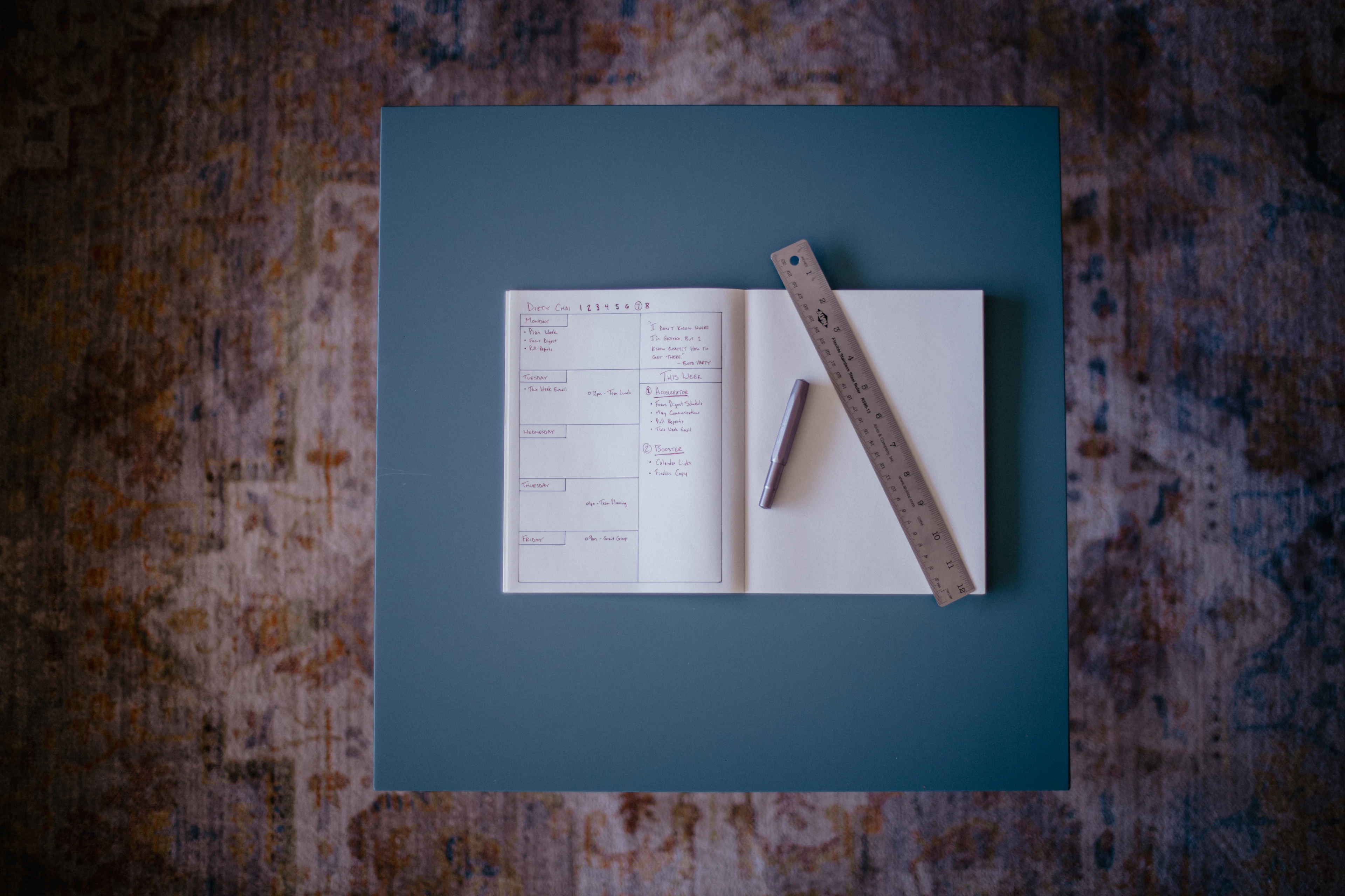 A blank notebook, pen and ruler arranged for design planning