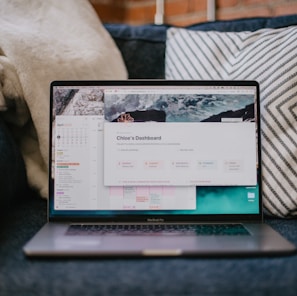 a laptop computer sitting on top of a blue couch