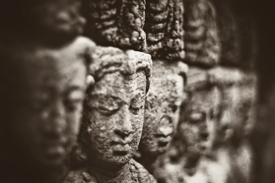 Ancient stone carvings of Mesopotamian deities under soft lighting.