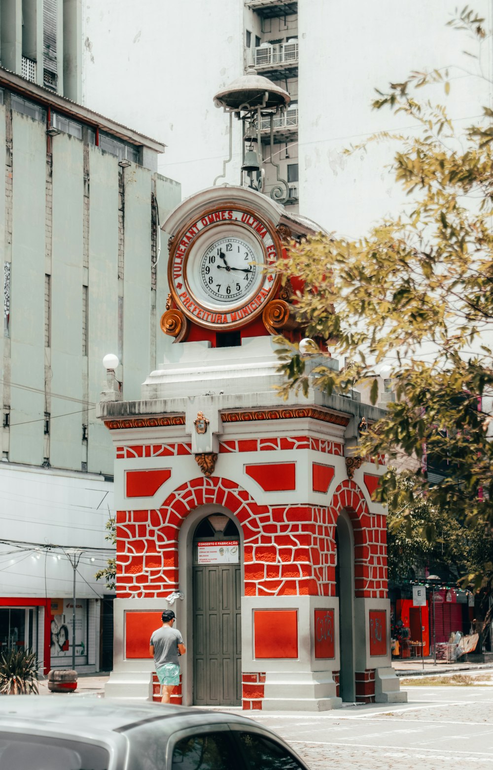 Una torre de reloj roja y blanca en una calle de la ciudad