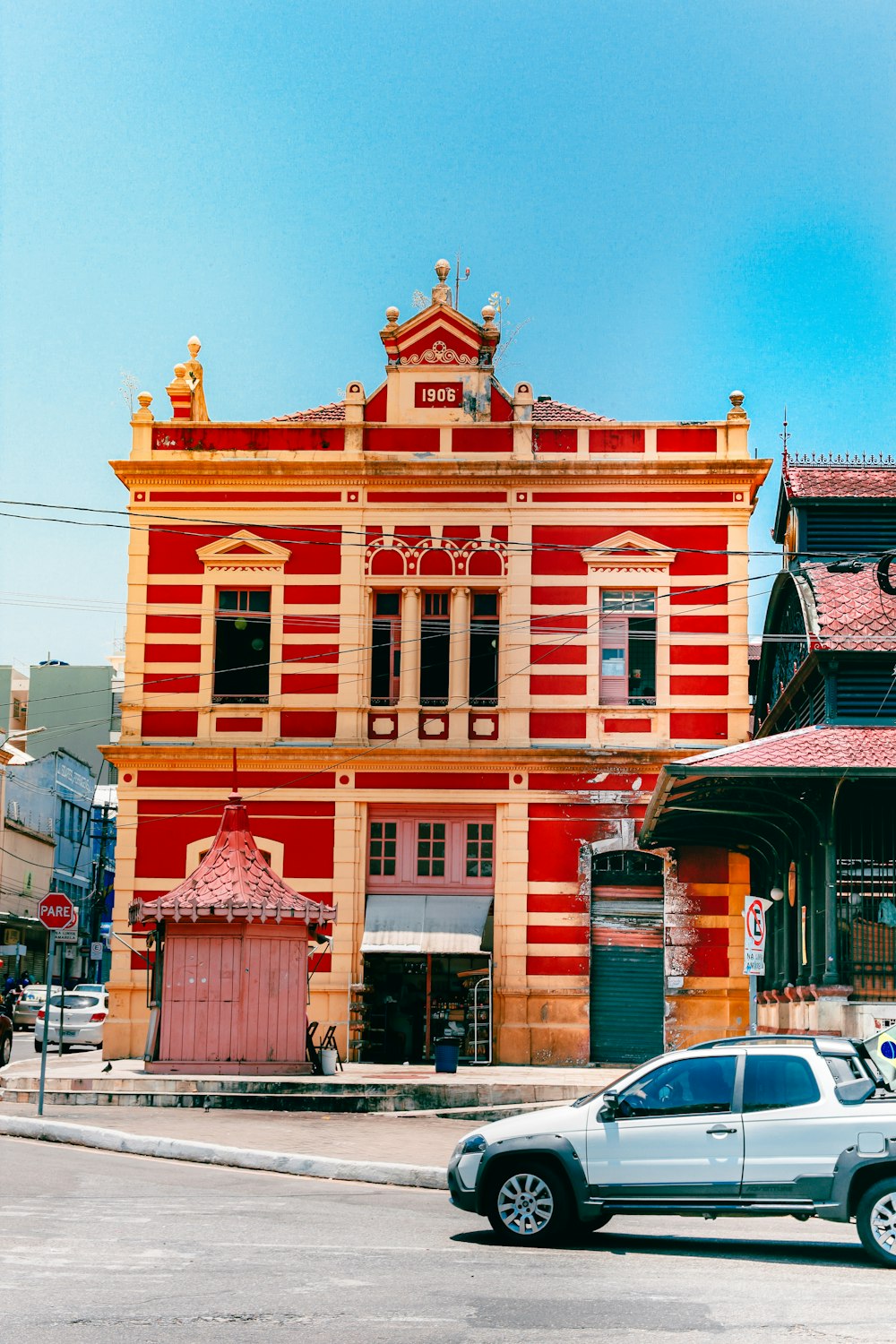 a car parked in front of a red and yellow building