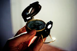 Close-up of a hand placing a Vastu compass on a blueprint under a glowing constellation map.