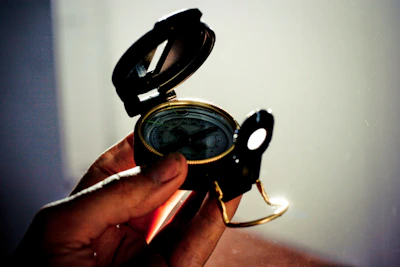 Close-up of a hand placing a Vastu compass on a blueprint under a glowing constellation map.