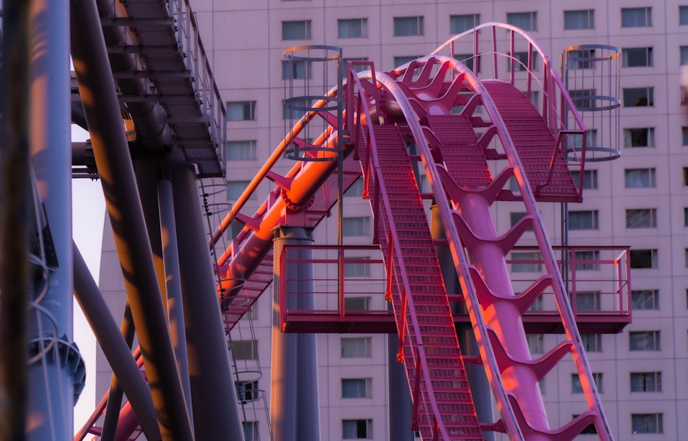 a roller coaster in front of a tall building