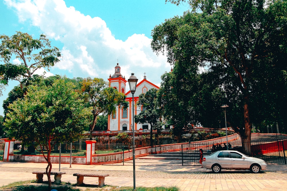 a white car parked in front of a church