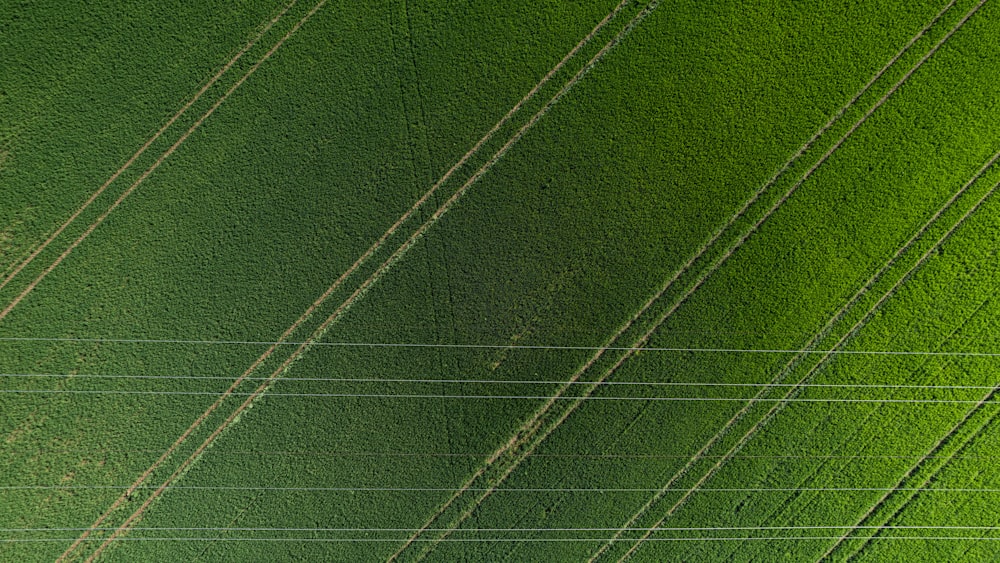 an aerial view of a green field with power lines