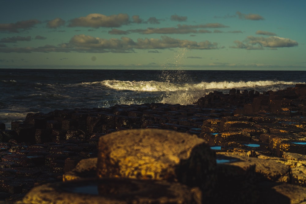 a rocky shore with waves crashing against the rocks