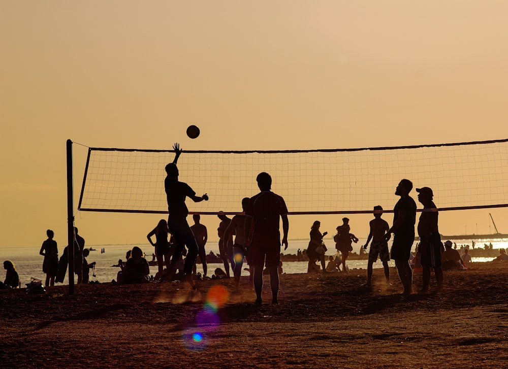 un gruppo di persone che giocano a pallavolo sulla spiaggia