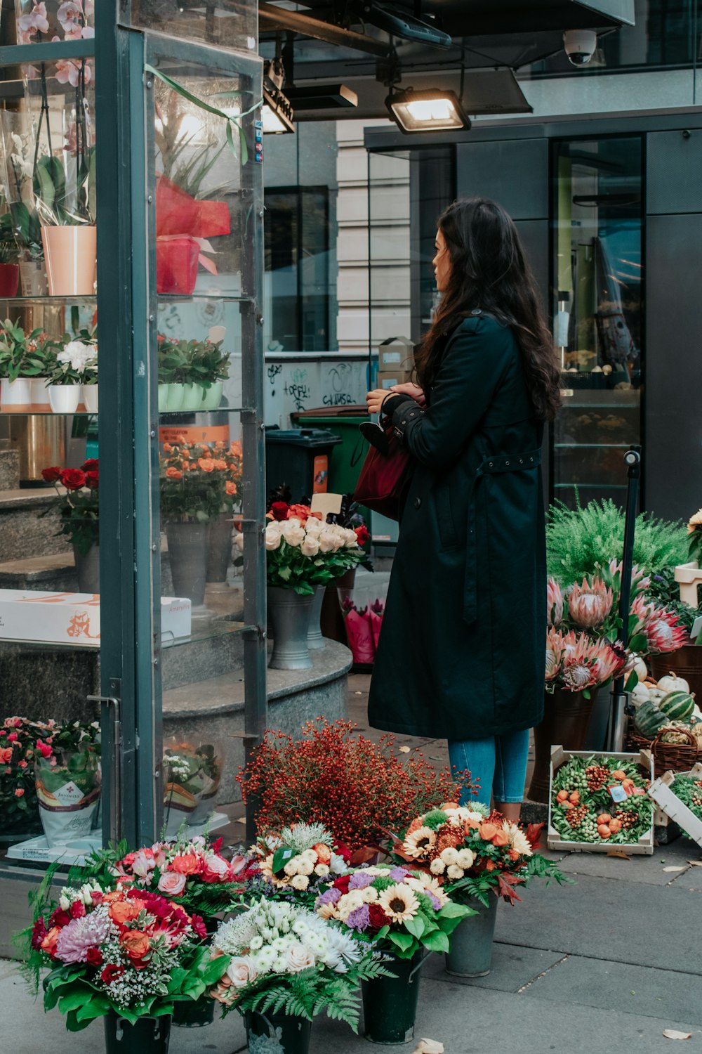 a woman standing in front of a flower shop