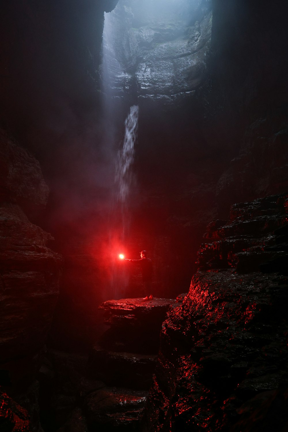 a dark cave with a waterfall coming out of it