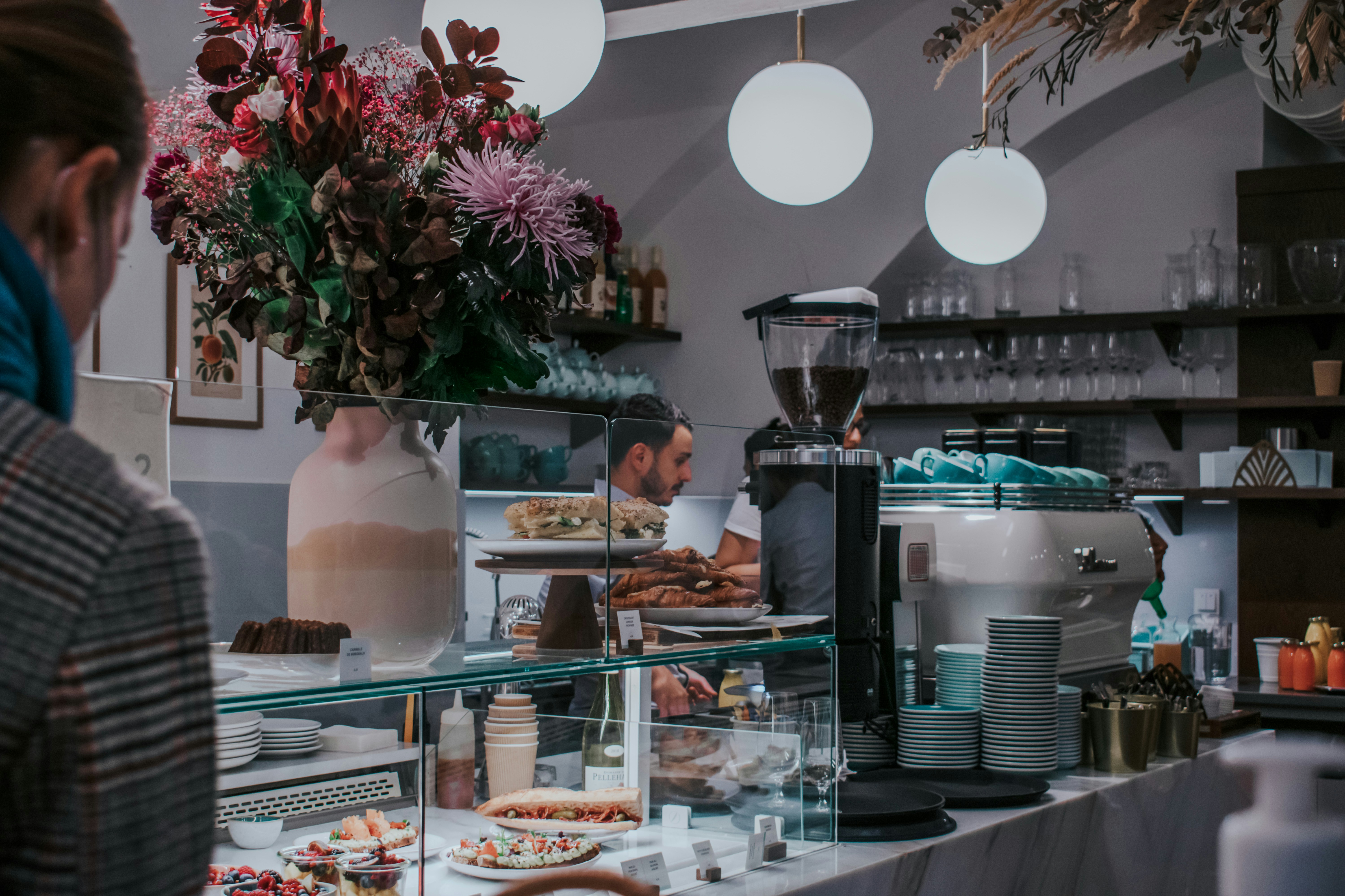 Una mujer parada frente a un mostrador lleno de comida