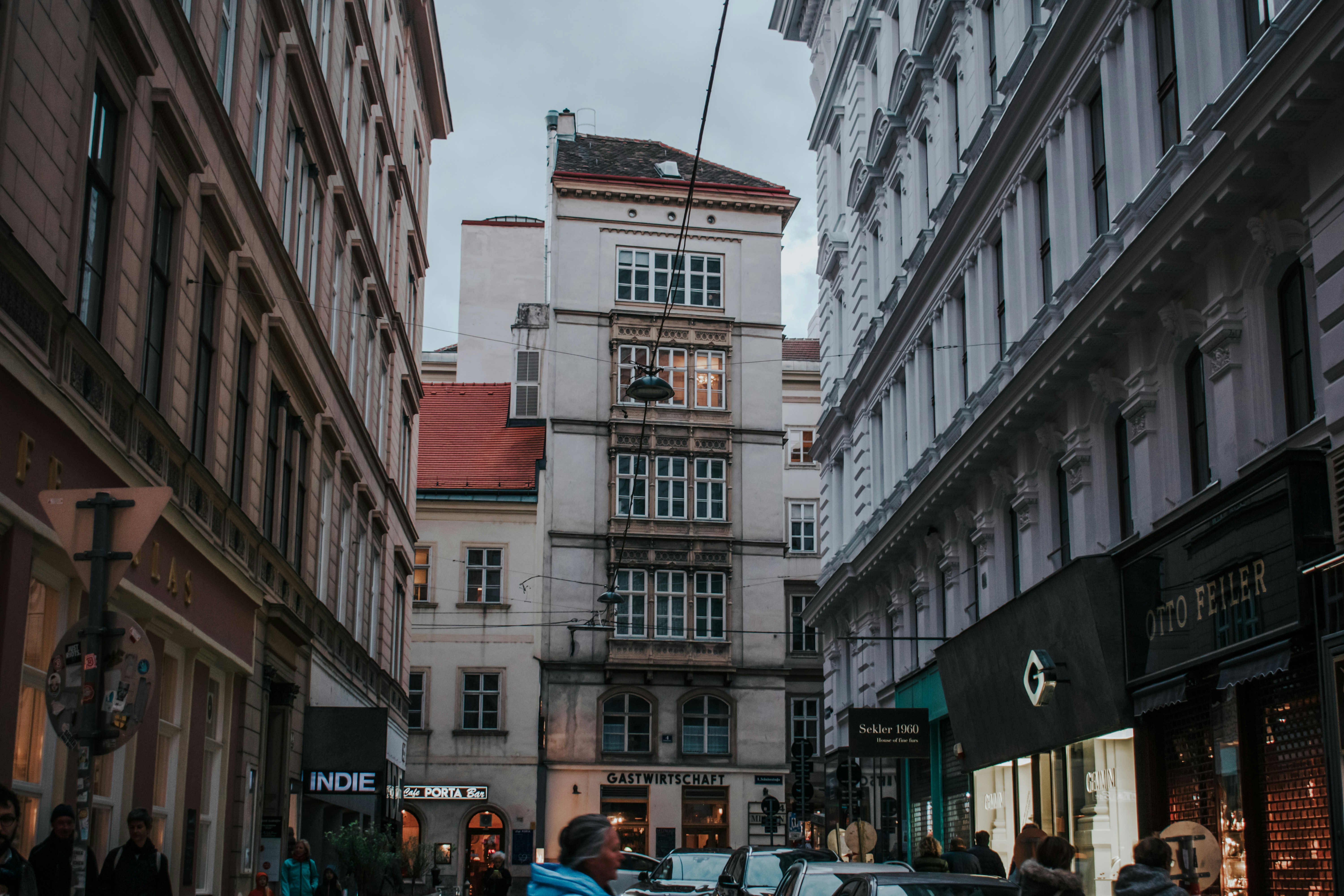 Un grupo de personas caminando por una calle junto a edificios altos