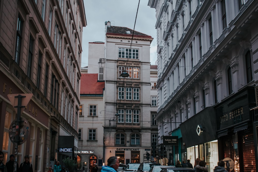 a group of people walking down a street next to tall buildings