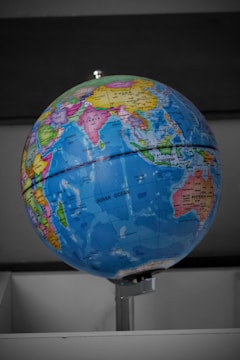 A globe with children pointing at different countries.