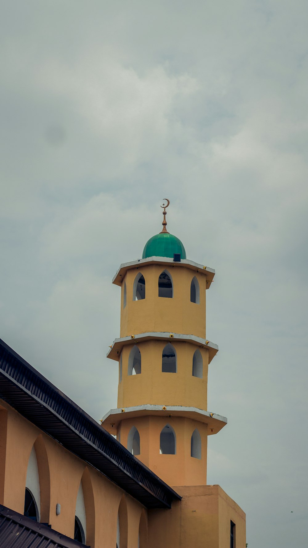 a tall yellow tower with a green top