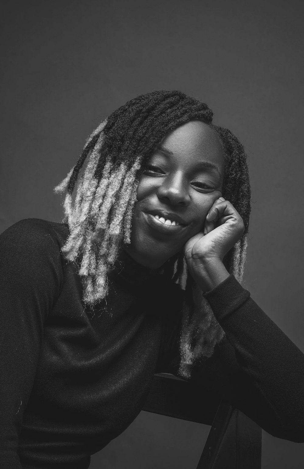 a woman with dreadlocks sitting in a chair