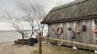 A cozy wooden barn by the beach with handcrafted decor items arranged on a weathered table.