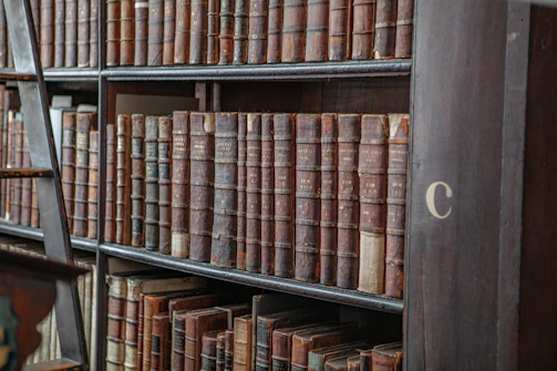 An old bookshelf filled with worn books and a small vintage globe