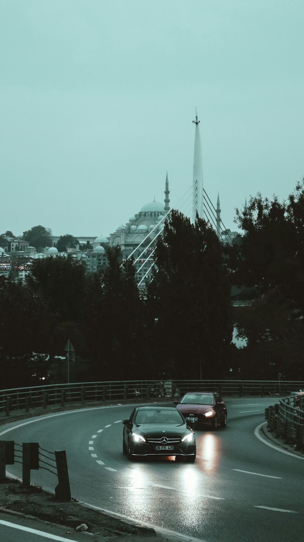 a couple of cars driving down a curvy road