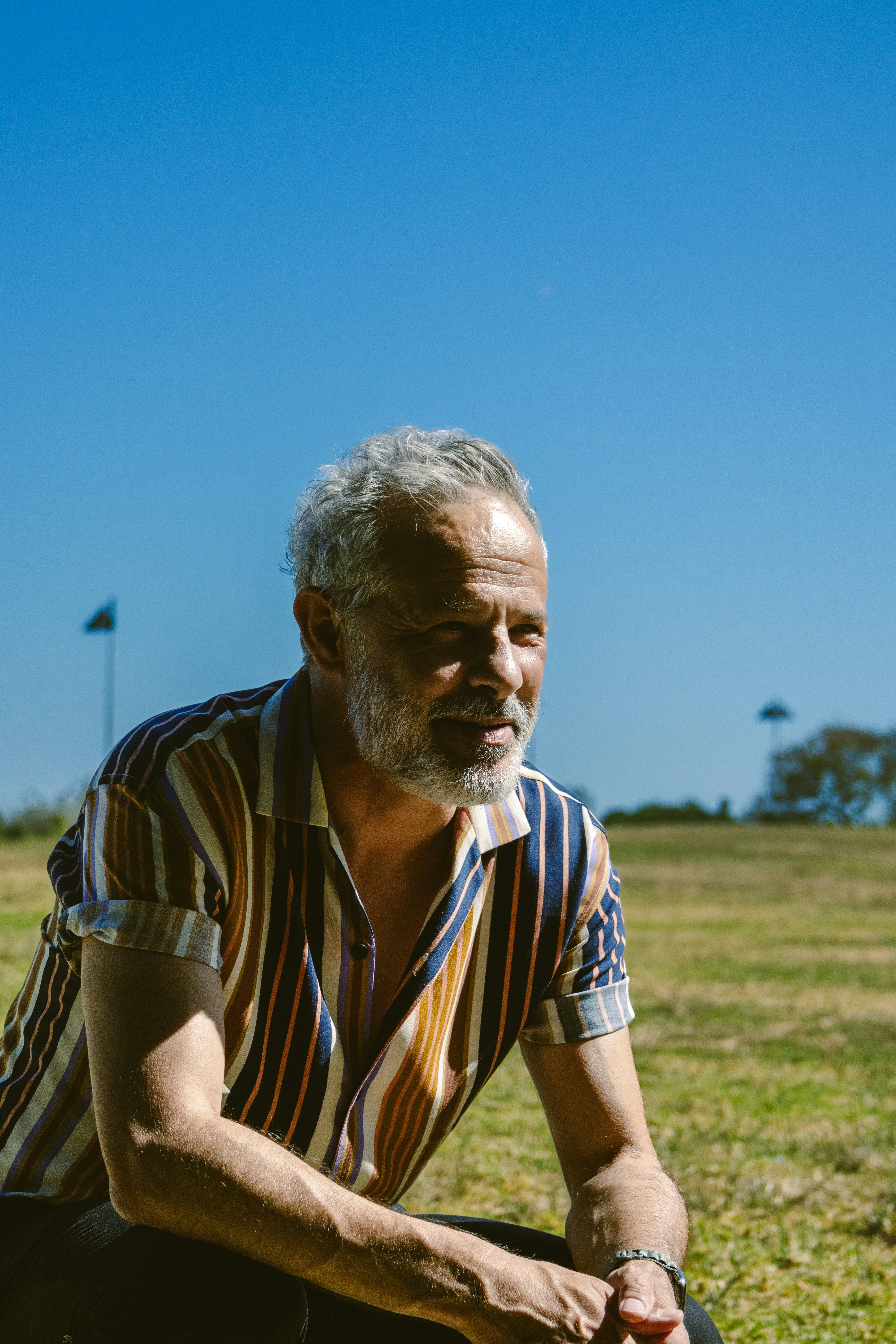 a man sitting on the ground in a field
