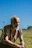 a man sitting on the ground in a field