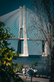 a group of people walking across a bridge