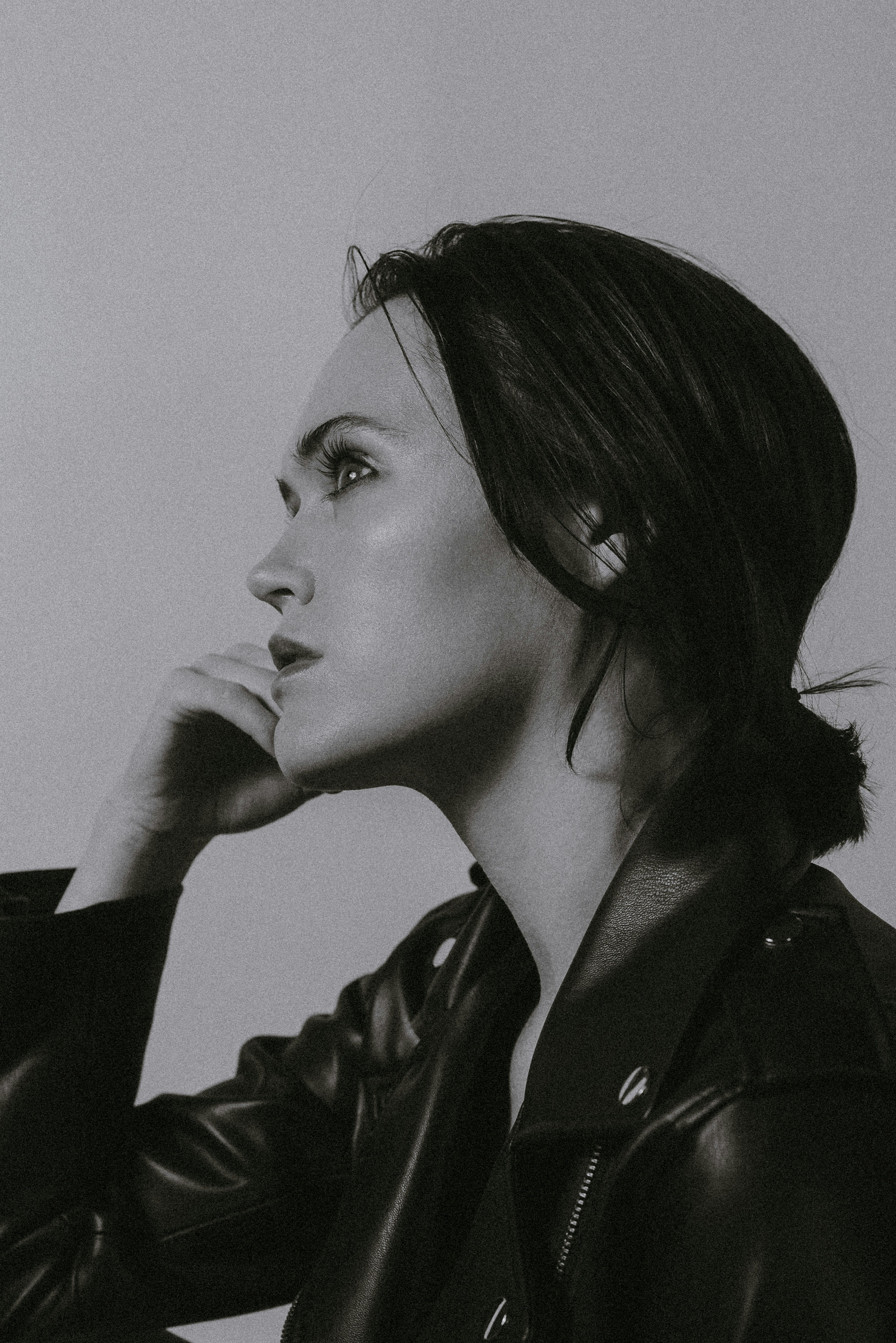 a black and white photo of a woman in a leather jacket