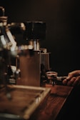 Close-up of hands grinding coffee beans freshly for an atelier demonstration.