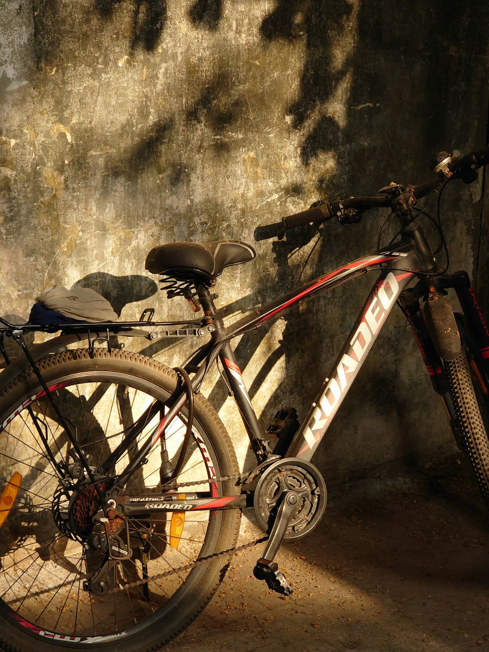 a bicycle parked next to a stone wall