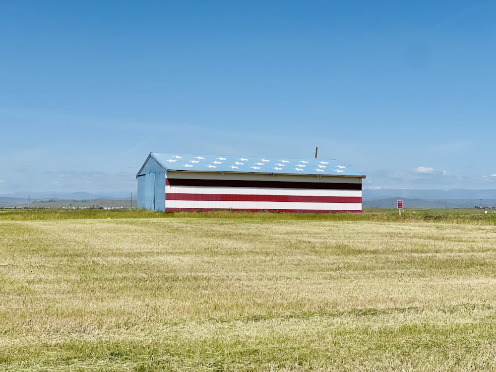 a red, white and blue barn in a field
