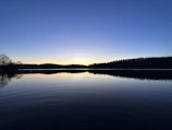 A serene moment of reflection by a calm lake, symbolizing personal transition and clarity.