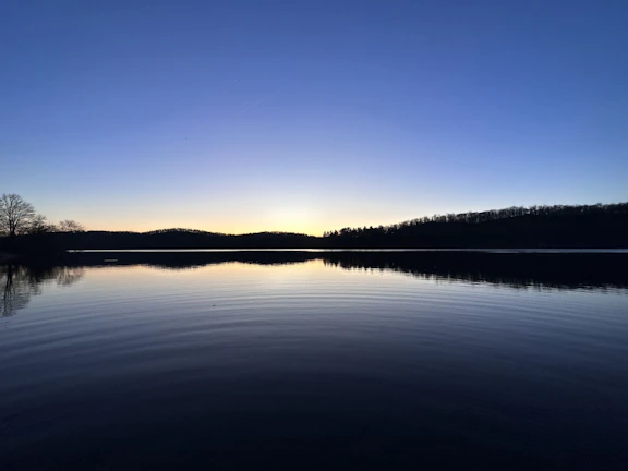 A serene moment of reflection by a calm lake, symbolizing personal transition and clarity.