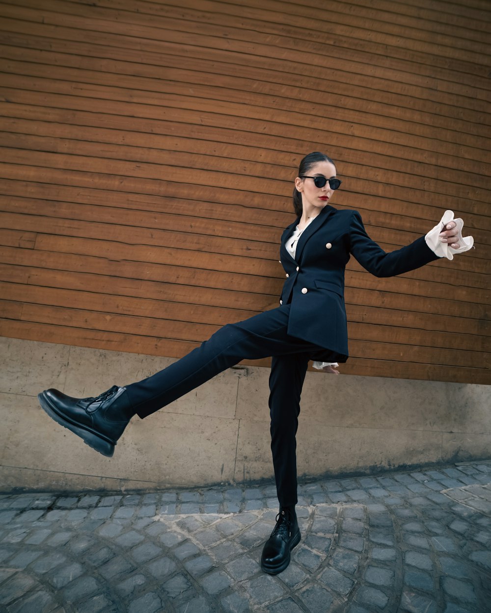 a woman in a suit and sunglasses posing for a picture